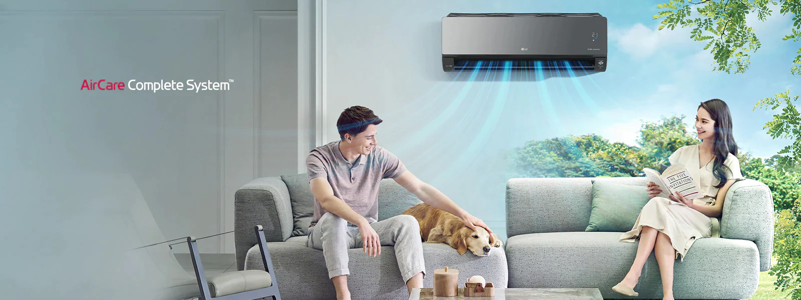 Mladi par sjedi na kauču u dnevnom boravku sa svojim psom dok klima uređaj LG AirCare Complete System hladi prostor.